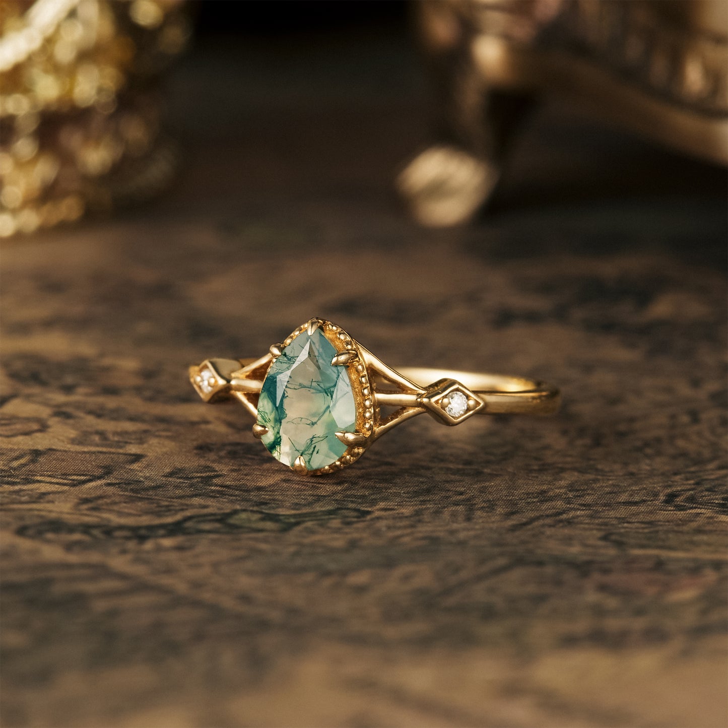Elegant moss agate pear ring with gold setting and moissanite side stones