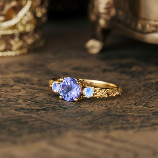Unique tanzanite and moonstone engagement ring with gold twist band and leaf design