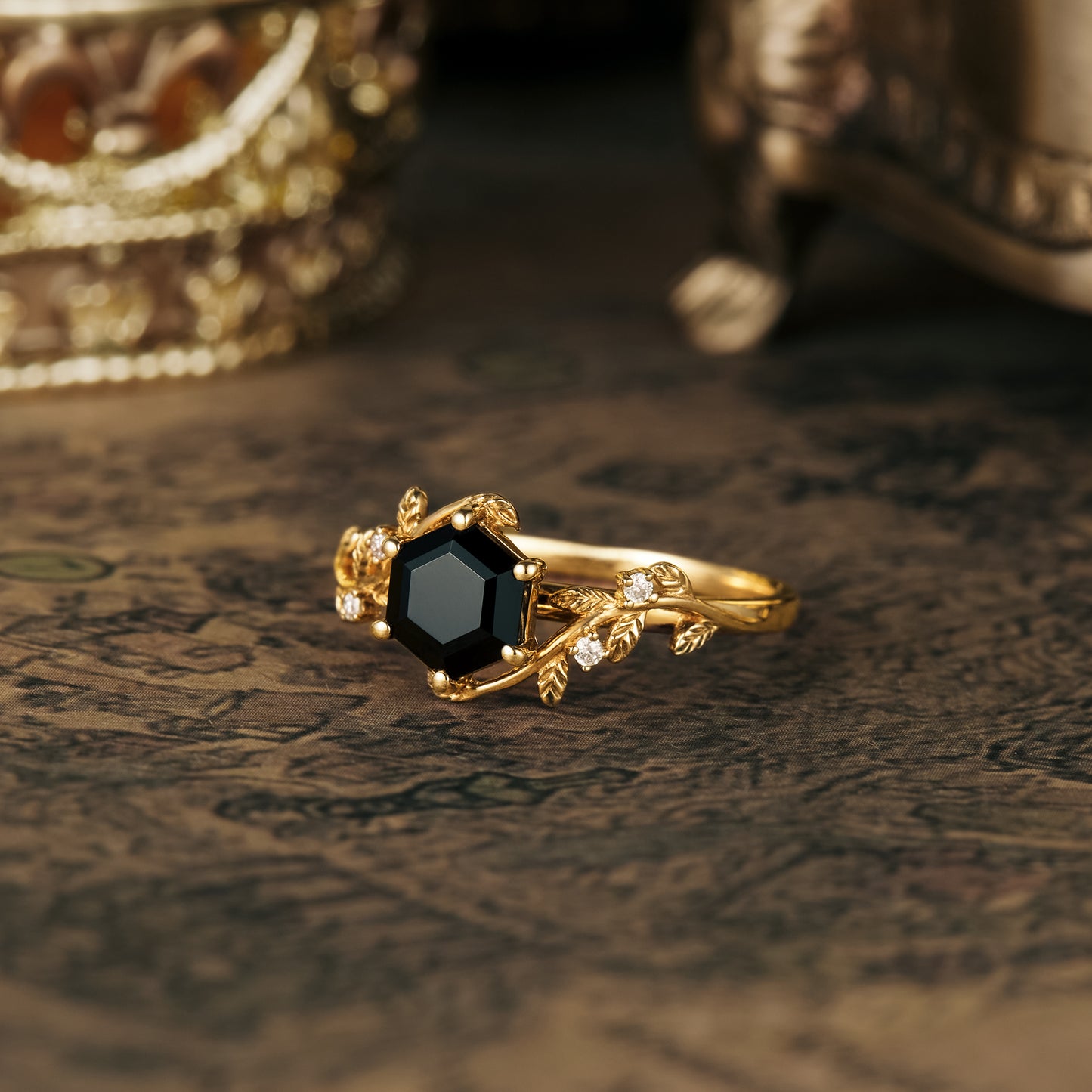 Black onyx hexagon engagement ring with nature-inspired leaf accents in gold.
