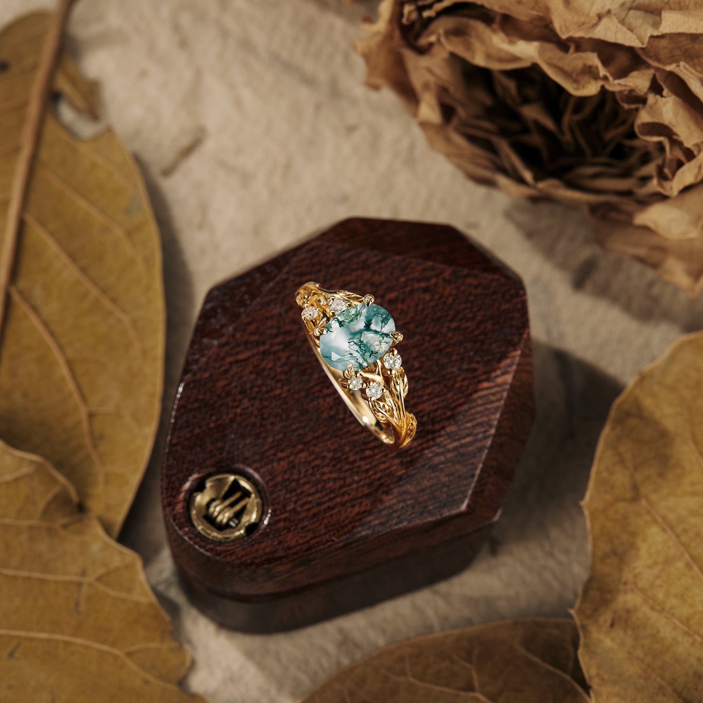 Blue moss agate ring with gold leaf accents on wooden box with dried leaves