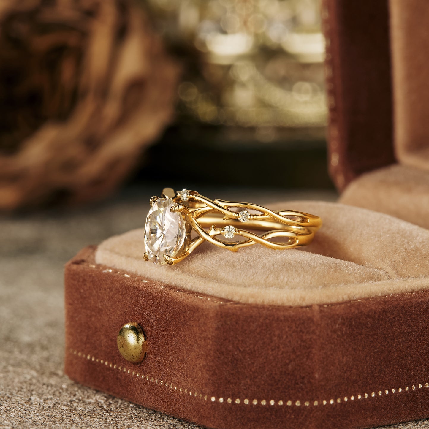 Oval moissanite floral engagement ring set in twisted gold display box.