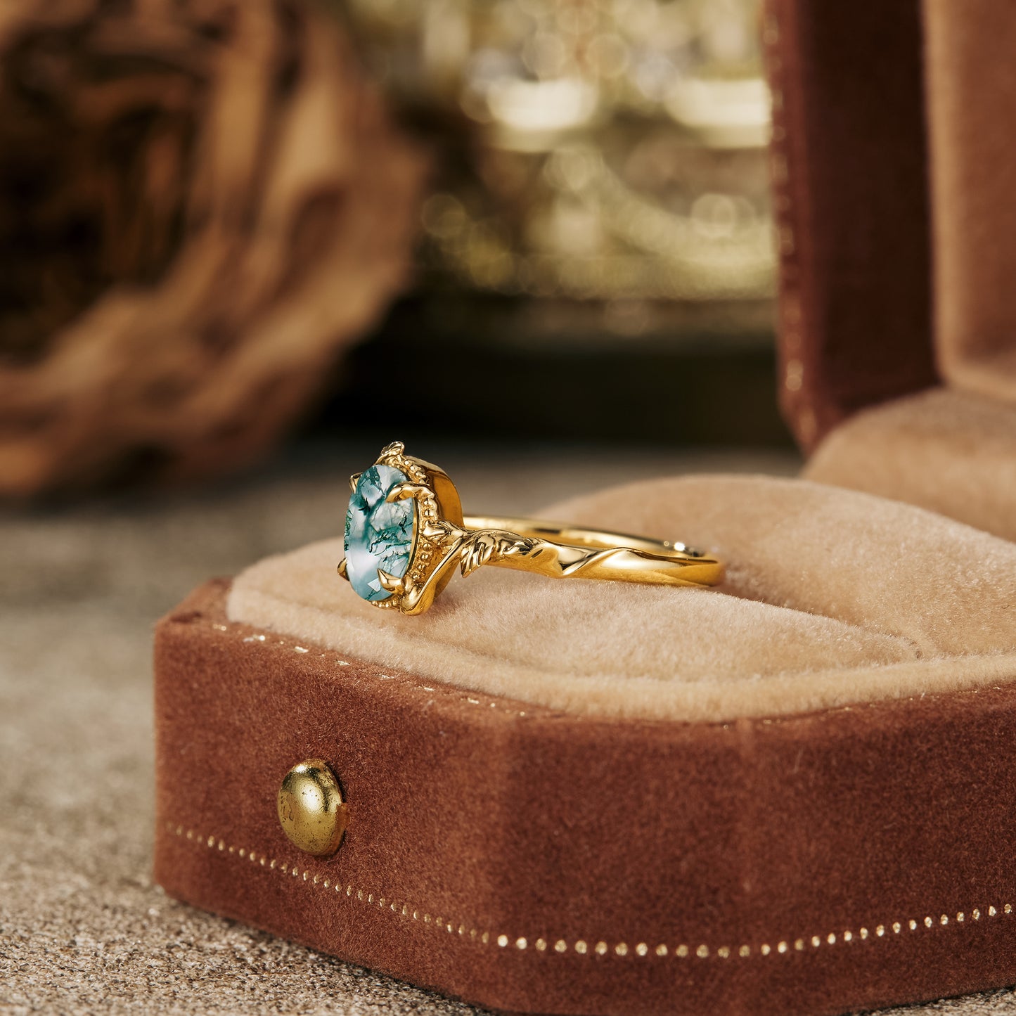 Elegant moss agate engagement ring in gold leaf setting displayed in velvet box