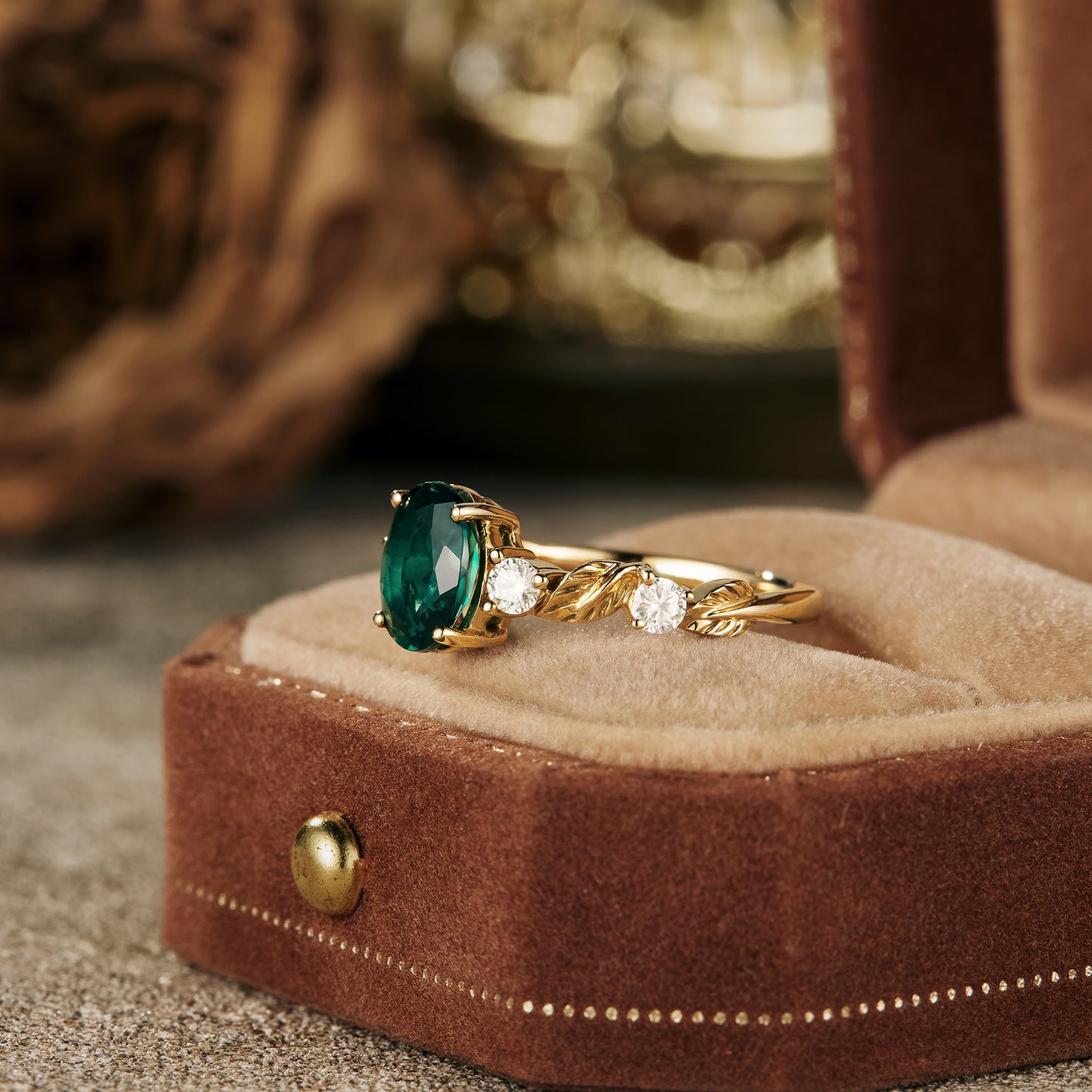 Nature-inspired emerald engagement ring with moissanite in a gold band