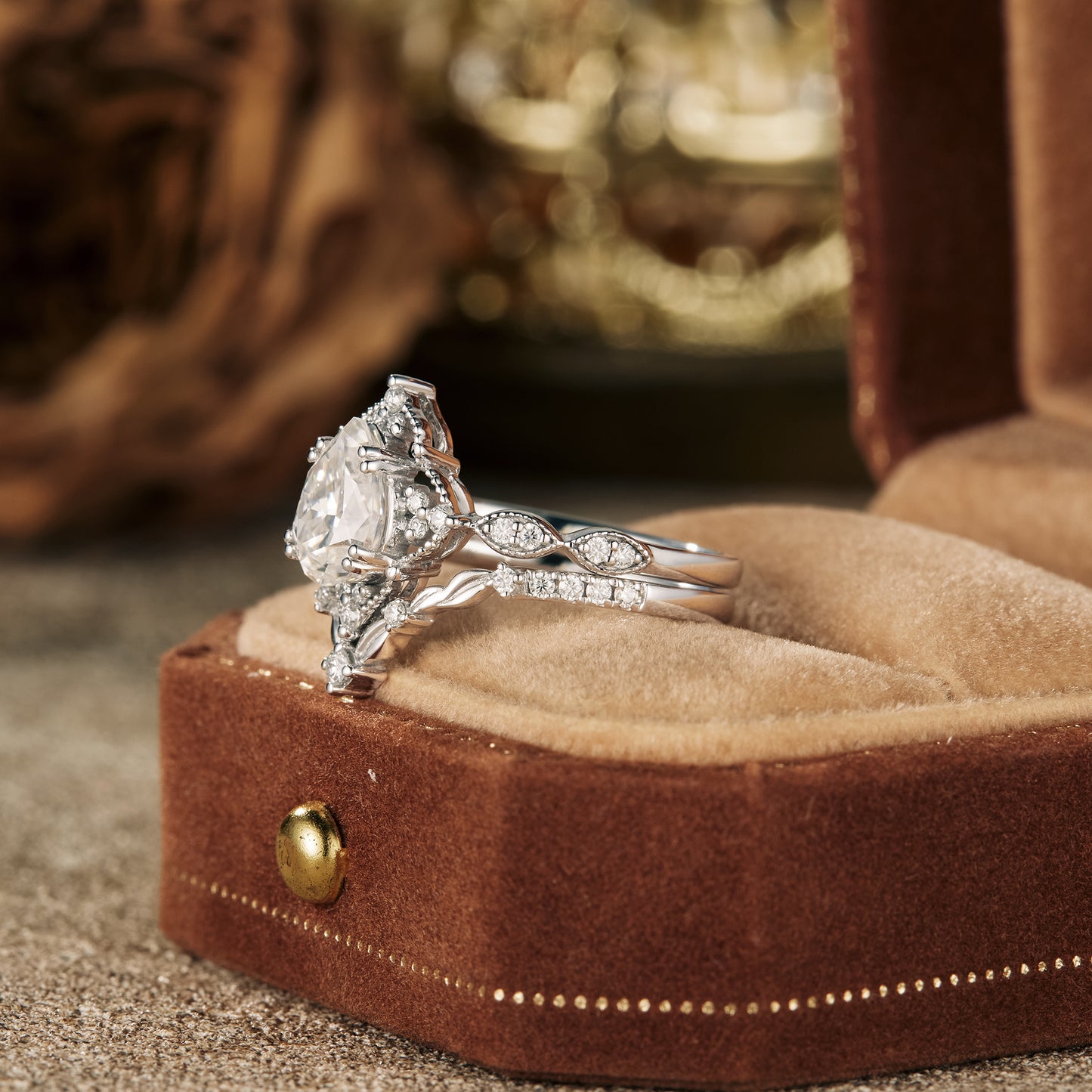 Vintage pear-shaped moissanite engagement ring on a plush ring box.